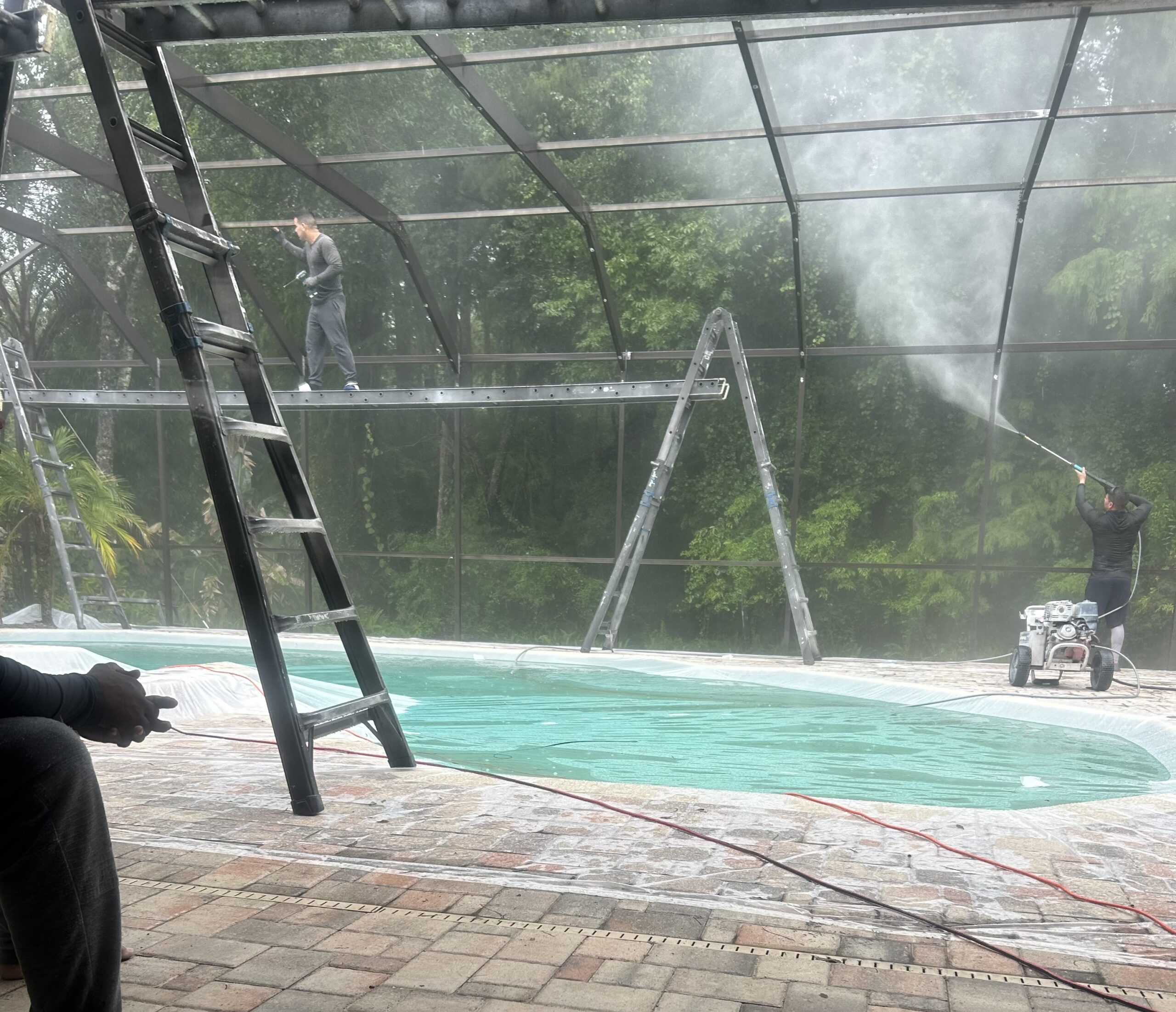 Pressure cleaning pool cage and replacing screws with walkboard access in Tampa Palms