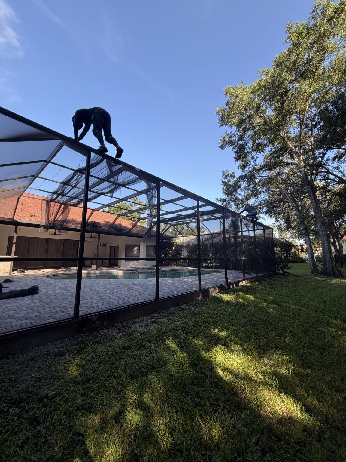New pool cage screen being installed and tensioned in Tampa Palms Tampa Florida